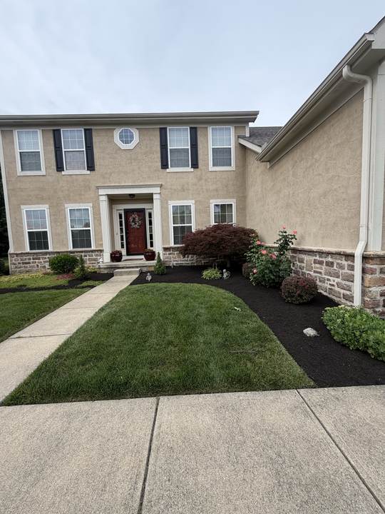 Front entry beds freshly mulched, with a clean edge along the lawn